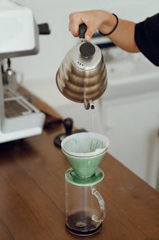 Crop female barista preparing coffee in cafe