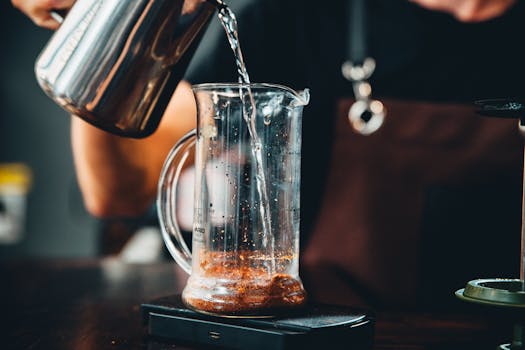 Person Pouring Liquid in Clear Glass Pitcher